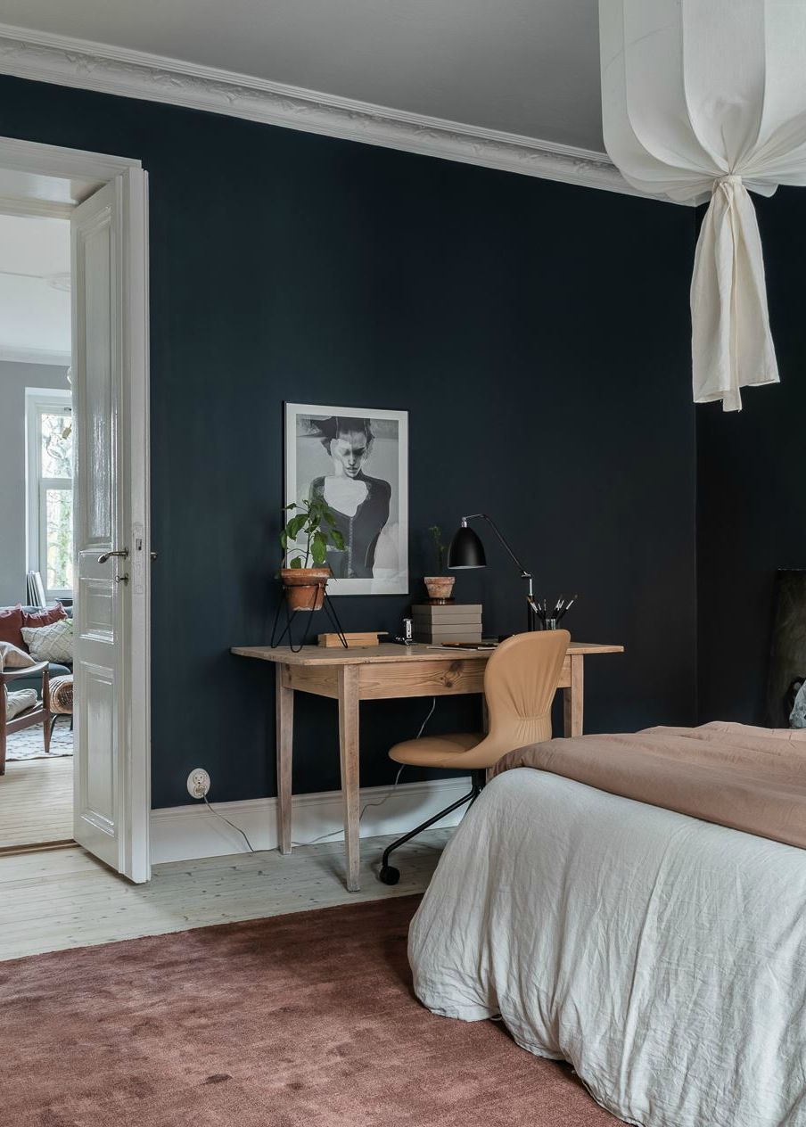 Osa kotitoimistoa, tilavassa makuuhuoneessa tummat seinät 